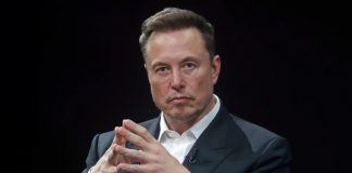 Elon Musk Critiques IRS Technology, Advocates for Modernization Elon Musk seated in a formal suit with a thoughtful expression, emphasizing his remarks on outdated government technology systems.