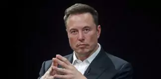 Elon Musk Critiques IRS Technology, Advocates for Modernization Elon Musk seated in a formal suit with a thoughtful expression, emphasizing his remarks on outdated government technology systems.